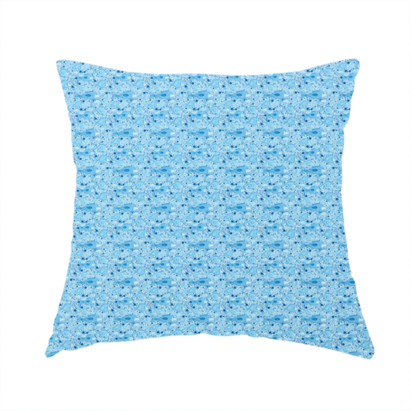 The fabric used to create this handmade cushion is a light blue fabric print featuring a repetitive, minimalist pattern of tiny whales and scattered bubbles. The design uses varying shades of blue to create a soft, calming, and playful aquatic aesthetic.
