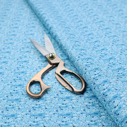 A light blue fabric print featuring a repetitive, minimalist pattern of tiny whales and scattered bubbles. The design uses varying shades of blue to create a soft, calming, and playful aquatic aesthetic.