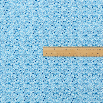 A light blue fabric print featuring a repetitive, minimalist pattern of tiny whales and scattered bubbles. The design uses varying shades of blue to create a soft, calming, and playful aquatic aesthetic.