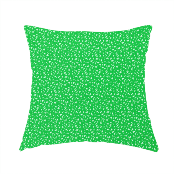 The fabric used to create this handmade cushion is a bright, vibrant green fabric print featuring a repetitive, minimalist pattern of small, white, irregular flecks or specks. The design creates a textured, clean, and modern look.