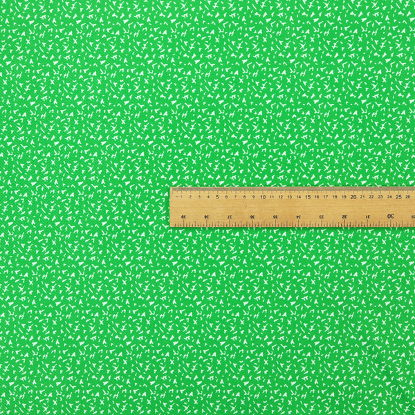 A bright, vibrant green fabric print featuring a repetitive, minimalist pattern of small, white, irregular flecks or specks. The design creates a textured, clean, and modern look.