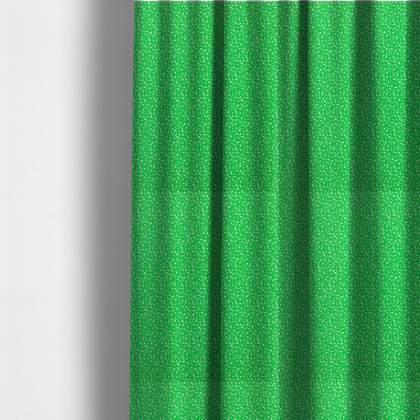 The fabric used to create these made-to-measure curtains is a bright, vibrant green fabric print featuring a repetitive, minimalist pattern of small, white, irregular flecks or specks. The design creates a textured, clean, and modern look.