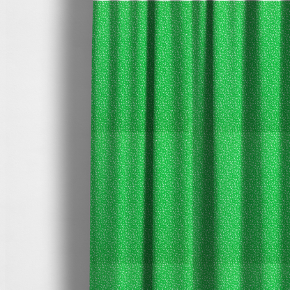 The fabric used to create these made-to-measure curtains is a bright, vibrant green fabric print featuring a repetitive, minimalist pattern of small, white, irregular flecks or specks. The design creates a textured, clean, and modern look.