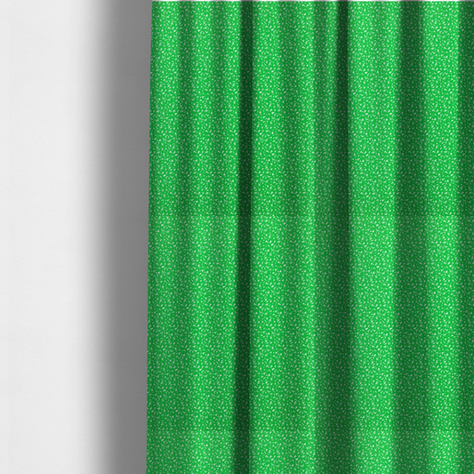 The fabric used to create these made-to-measure curtains is a bright, vibrant green fabric print featuring a repetitive, minimalist pattern of small, white, irregular flecks or specks. The design creates a textured, clean, and modern look.
