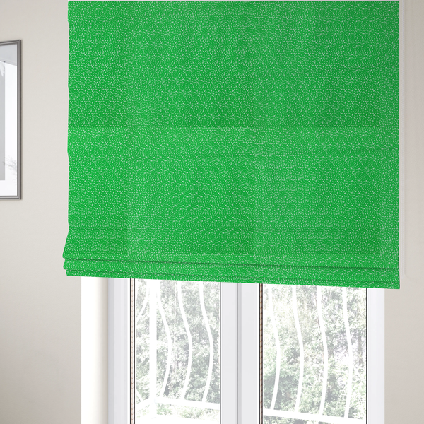 The fabric used to create these Roman blinds is a bright, vibrant green fabric print featuring a repetitive, minimalist pattern of small, white, irregular flecks or specks. The design creates a textured, clean, and modern look.