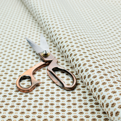Micro-scale ditsy fabric pattern featuring rows of tiny brown paw prints and beige hearts arranged in a dense polka dot grid on a pale blue background.