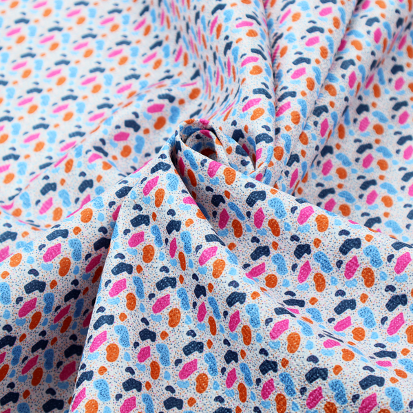 This fabric features a playful, confetti-inspired terrazzo pattern set against a light grey, speckled background.