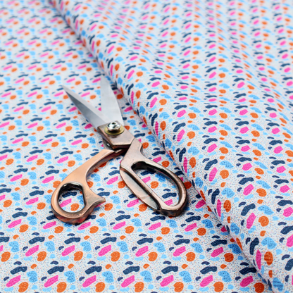 This fabric features a playful, confetti-inspired terrazzo pattern set against a light grey, speckled background.