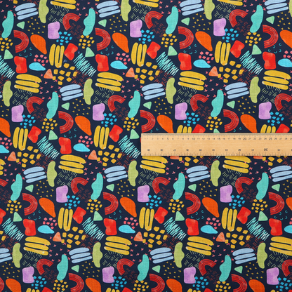 This fabric features a lively, abstract pattern set against a deep navy background. The design is filled with a dense, colourful array of hand-drawn shapes, including squiggles, small arches, and organic blobs in a vibrant palette of yellow, red, orange, teal, light blue, and purple.