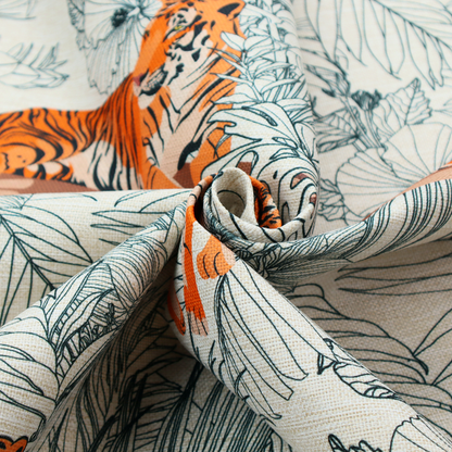 This fabric features a repeating botanical and wildlife pattern set against a light cream and grey background. The design showcases tigers in two poses—some walking and some resting—interspersed with detailed line drawings of large tropical leaves and hibiscus flowers.