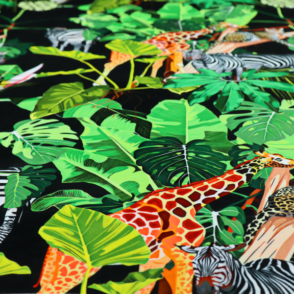 This fabric features a lush, vibrant jungle scene set against a deep black background. The pattern is filled with a dense variety of tropical foliage, including large monstera and palm leaves in multiple shades of green.