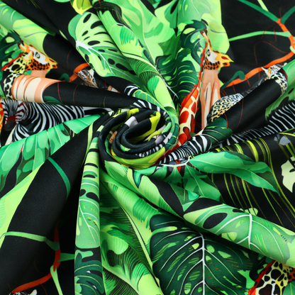 This fabric features a lush, vibrant jungle scene set against a deep black background. The pattern is filled with a dense variety of tropical foliage, including large monstera and palm leaves in multiple shades of green.