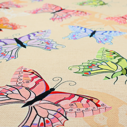 This fabric features a whimsical, repeating pattern of colourful butterflies scattered across a light beige, textured background. The butterflies are rendered in various sizes and a vibrant colour palette, including shades of pink, purple, lime green, and soft blue, with delicate black wing detailing.