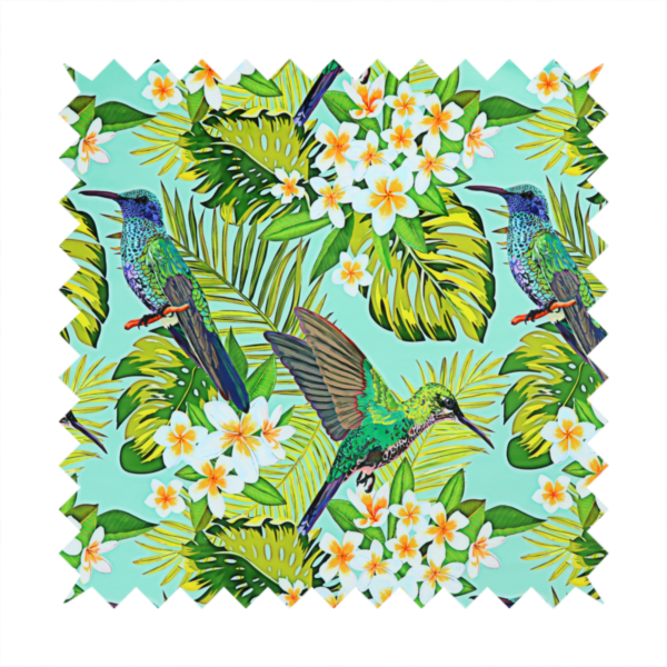 This fabric features a vibrant, tropical pattern set against a bright turquoise background. The design showcases hummingbirds in various poses—some perched and others in flight—surrounded by clusters of white plumeria flowers and lush, layered palm and monstera leaves in shades of green and yellow.