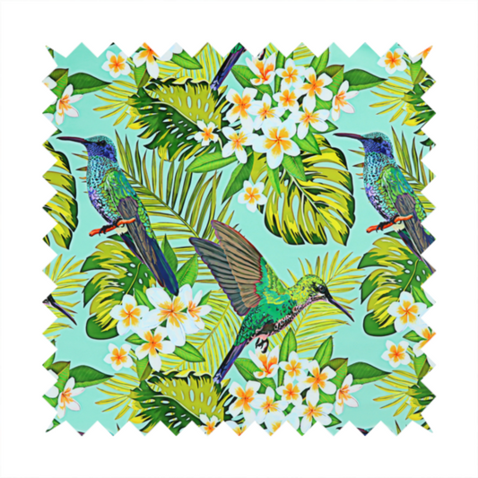 This fabric features a vibrant, tropical pattern set against a bright turquoise background. The design showcases hummingbirds in various poses—some perched and others in flight—surrounded by clusters of white plumeria flowers and lush, layered palm and monstera leaves in shades of green and yellow.