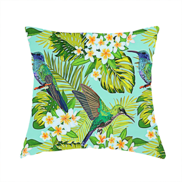 The fabric used to create this handmade cushion is a fabric features a vibrant, tropical pattern set against a bright turquoise background. The design showcases hummingbirds in various poses—some perched and others in flight—surrounded by clusters of white plumeria flowers and lush, layered palm and monstera leaves in shades of green and yellow.
