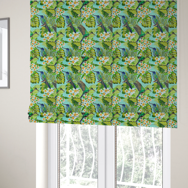 The fabric used to create these Roman blinds is a fabric features a vibrant, tropical pattern set against a bright turquoise background. The design showcases hummingbirds in various poses—some perched and others in flight—surrounded by clusters of white plumeria flowers and lush, layered palm and monstera leaves in shades of green and yellow.