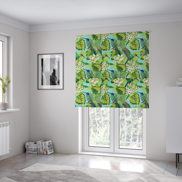 The fabric used to create these Roman blinds is a fabric features a vibrant, tropical pattern set against a bright turquoise background. The design showcases hummingbirds in various poses—some perched and others in flight—surrounded by clusters of white plumeria flowers and lush, layered palm and monstera leaves in shades of green and yellow.