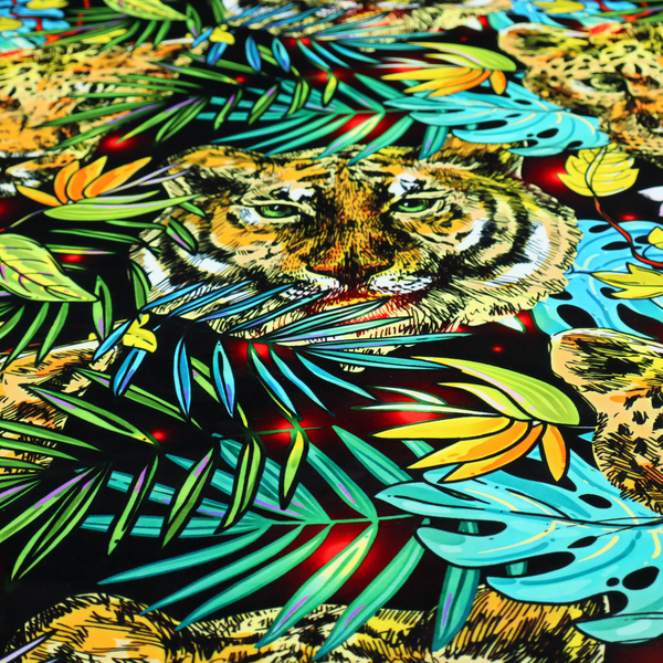 This fabric features a bold, artistic jungle-themed pattern set against a dark black background. The design is a dense, repeating collage of wildlife portraits, featuring alternating heads of leopards and tigers with intense, detailed expressions.