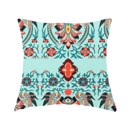 The fabric used to create this handmade cushion is a  fabric features an intricate, symmetrical folk-art inspired pattern set against a soft, light turquoise background. The design showcases stylized birds facing toward central, ornate floral bursts, rendered in a bold colour palette of vibrant red, deep orange, teal, and charcoal.