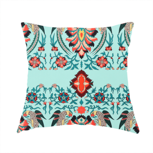 The fabric used to create this handmade cushion is a  fabric features an intricate, symmetrical folk-art inspired pattern set against a soft, light turquoise background. The design showcases stylized birds facing toward central, ornate floral bursts, rendered in a bold colour palette of vibrant red, deep orange, teal, and charcoal.
