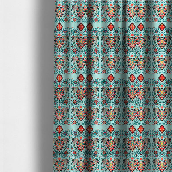 The fabric used to create these made-to-measure curtains is a fabric features an intricate, symmetrical folk-art inspired pattern set against a soft, light turquoise background. The design showcases stylized birds facing toward central, ornate floral bursts, rendered in a bold colour palette of vibrant red, deep orange, teal, and charcoal.