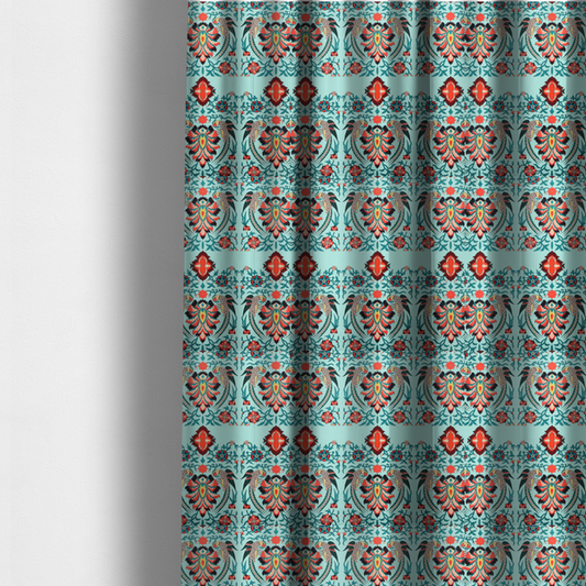 The fabric used to create these made-to-measure curtains is a fabric features an intricate, symmetrical folk-art inspired pattern set against a soft, light turquoise background. The design showcases stylized birds facing toward central, ornate floral bursts, rendered in a bold colour palette of vibrant red, deep orange, teal, and charcoal.