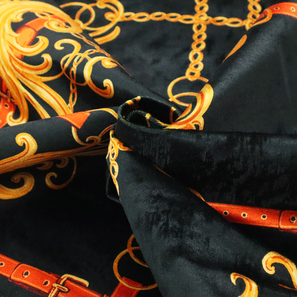 Luxury fashion fabric pattern featuring gold baroque acanthus scrolls layered over a grid of interlocking gold chains and red-orange leather straps on a black background.