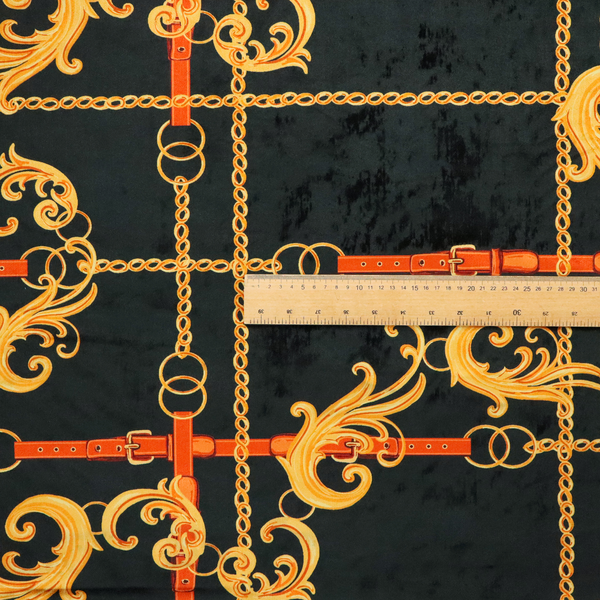 Luxury fashion fabric pattern featuring gold baroque acanthus scrolls layered over a grid of interlocking gold chains and red-orange leather straps on a black background.