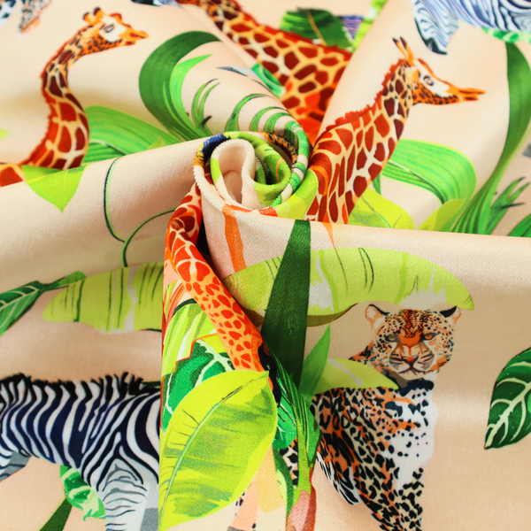Patterned fabric featuring a vibrant safari scene with giraffes, zebras, leopards, and snakes nestled among lush tropical palm leaves on a soft beige background.