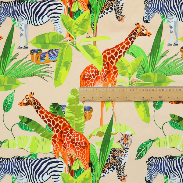 Patterned fabric featuring a vibrant safari scene with giraffes, zebras, leopards, and snakes nestled among lush tropical palm leaves on a soft beige background.