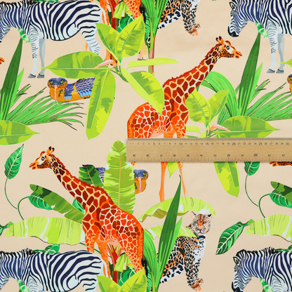 Patterned fabric featuring a vibrant safari scene with giraffes, zebras, leopards, and snakes nestled among lush tropical palm leaves on a soft beige background.