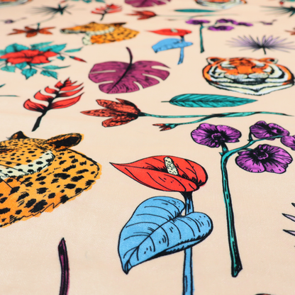 Patterned fabric featuring a repeating design of tiger and leopard heads interspersed with vibrant tropical flowers, orchids, and palm leaves on a cream background.