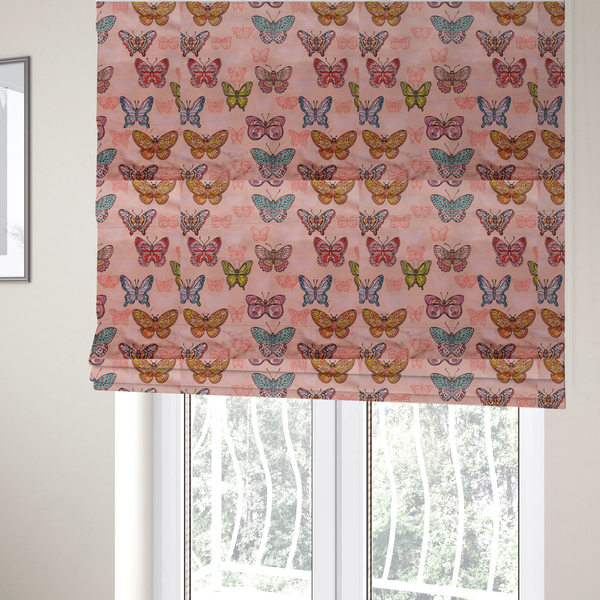 The fabric used to create these Roman blinds is a patterned fabric featuring a whimsical, repeating design of colourful butterflies in various patterns and shades—including orange, teal, pink, and yellow—scattered among faint, outline-style butterfly silhouettes on a soft, dusty pink background.