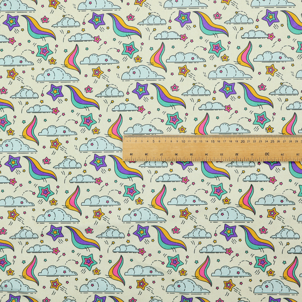 A whimsical, repeating fabric pattern featuring illustrated clouds, colourful shooting stars, and twinkling stars on a light cream background.