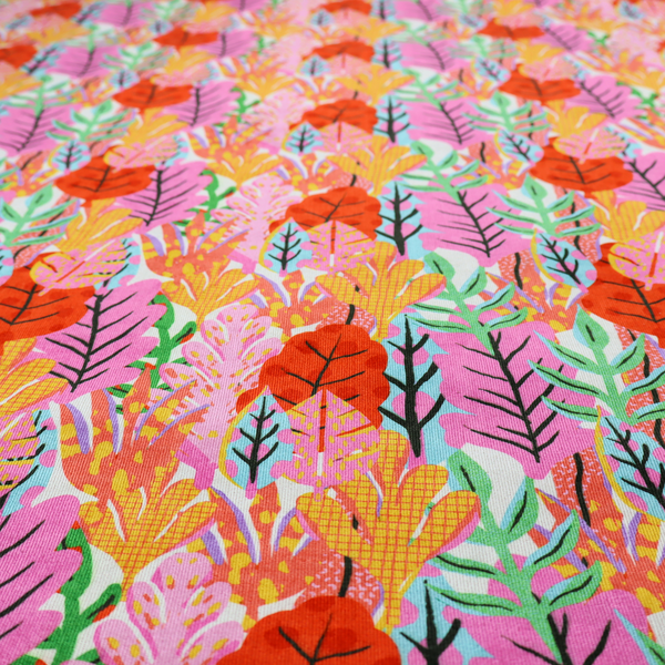 A vibrant, repeating textile pattern featuring a dense arrangement of stylized tropical leaves in saturated shades of pink, orange, yellow, and bright green against a white background.