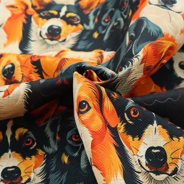 Vibrant fabric pattern featuring a dense, repeating arrangement of detailed, illustrated dog portraits of various herding breeds in bold orange, black, and cream colours.