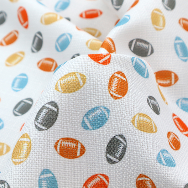 A white fabric featuring a playful, repeating pattern of small American footballs.