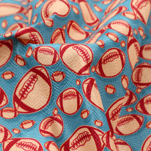 A vibrant blue fabric featuring a dense, repeating pattern of American footballs.