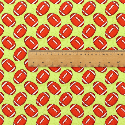 A vibrant lime green fabric featuring an orderly, repeating pattern of American footballs.