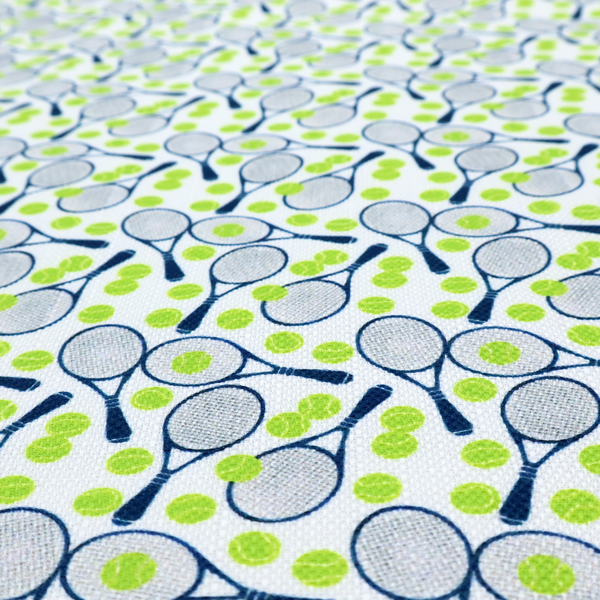 A white fabric featuring a vibrant, repeating pattern of tennis rackets and tennis balls.