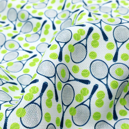 A white fabric featuring a vibrant, repeating pattern of tennis rackets and tennis balls.