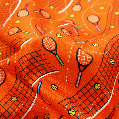a vibrant burnt orange fabric featuring a dynamic, repeating tennis-themed pattern.
