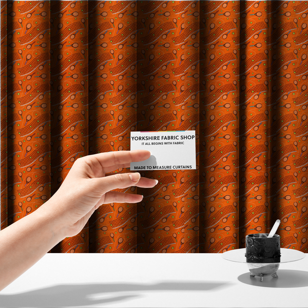 The fabric used to create these made-to-measure curtains is a vibrant burnt orange fabric featuring a dynamic, repeating tennis-themed pattern.