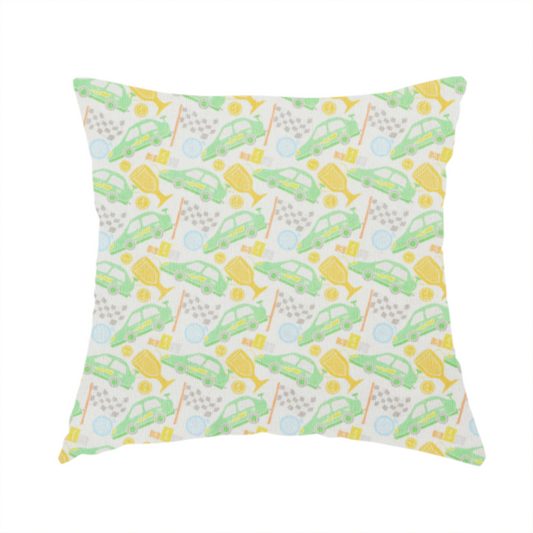 The fabric used to create this handmade cushion is a soft white fabric featuring a charming, repeating racing-themed pattern in a pastel colour palette.