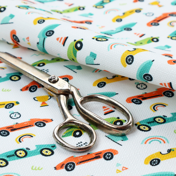 A fabric featuring a whimsical, repeating pattern of vintage-style racing cars and track accessories.
