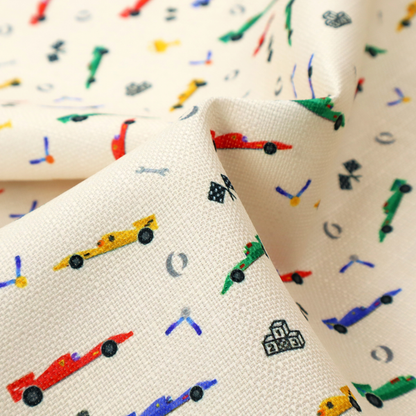 A cream-coloured fabric featuring a detailed, repeating pattern of Formula 1-style racing cars and track elements.