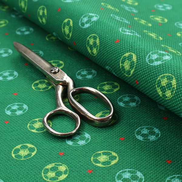 a rich emerald green fabric featuring a playful, repeating soccer and stars pattern.