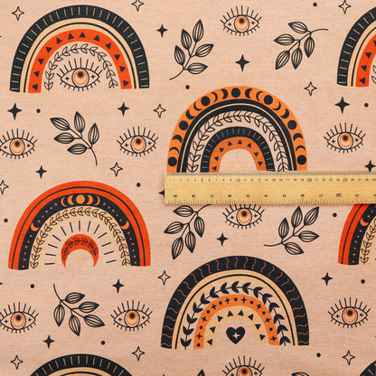 Seamless fabric pattern featuring bohemian style rainbows, mystic evil eyes, moon phases, and botanical leaves in terracotta orange, charcoal black, and tan.