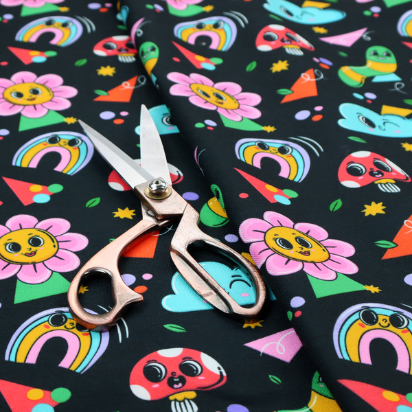 Seamless black fabric pattern featuring a colourful psychedelic print of retro cartoon mushrooms, smiling flowers, happy worms, winking clouds, and rainbow arches.